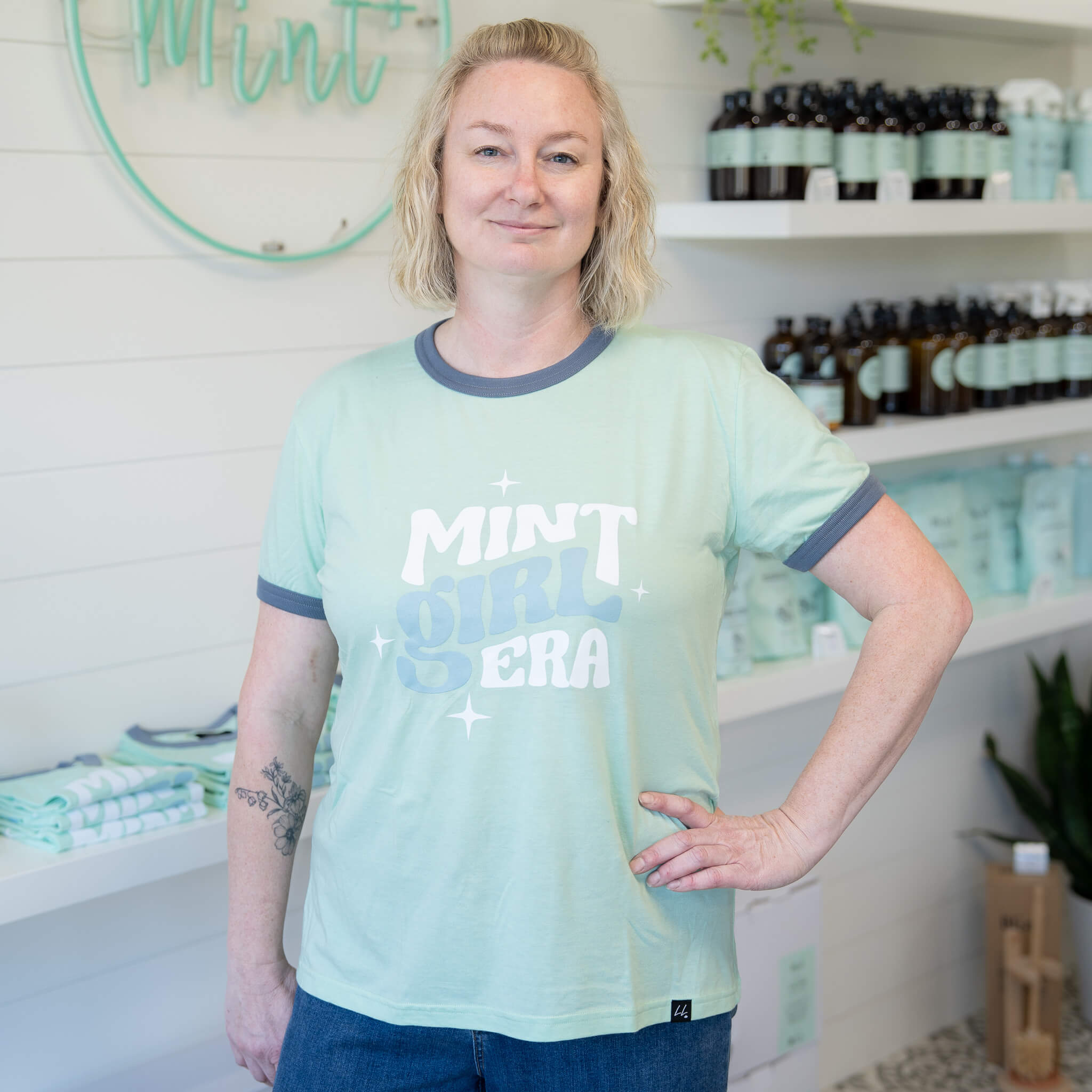 Person wearing a light green t-shirt with &