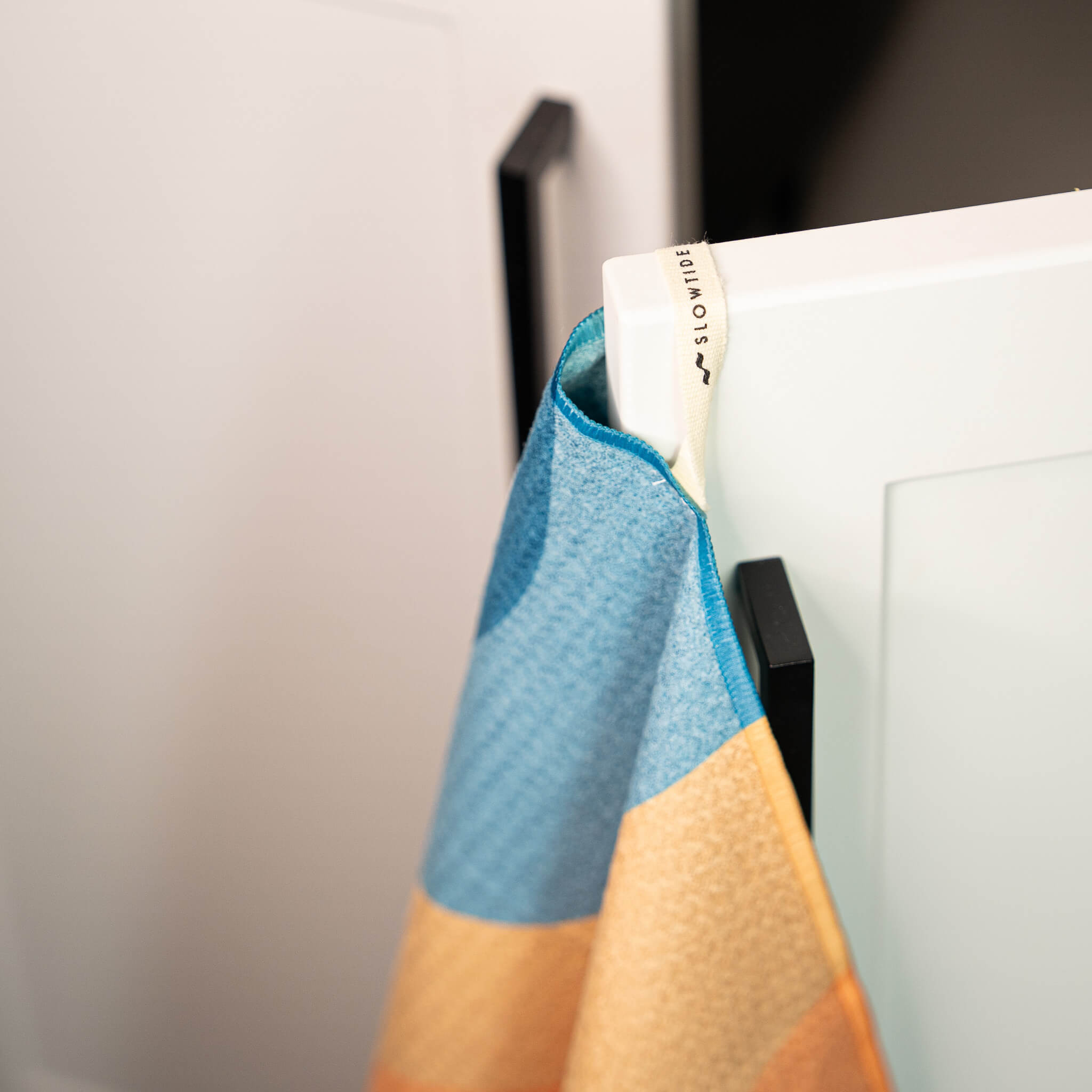 Colorful towel hanging on a door handle with a blurred background