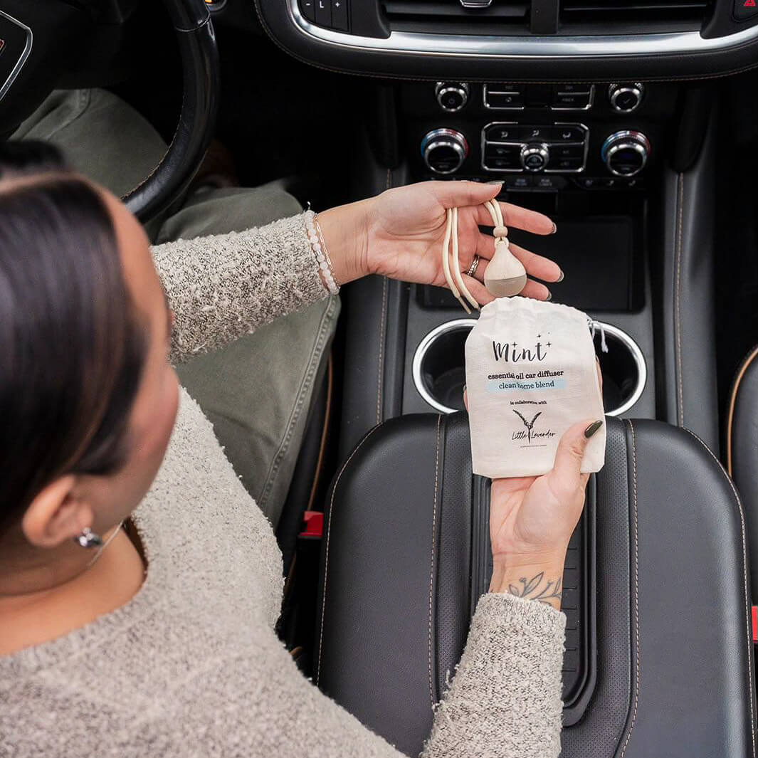 Person installing a car air freshener in a vehicle