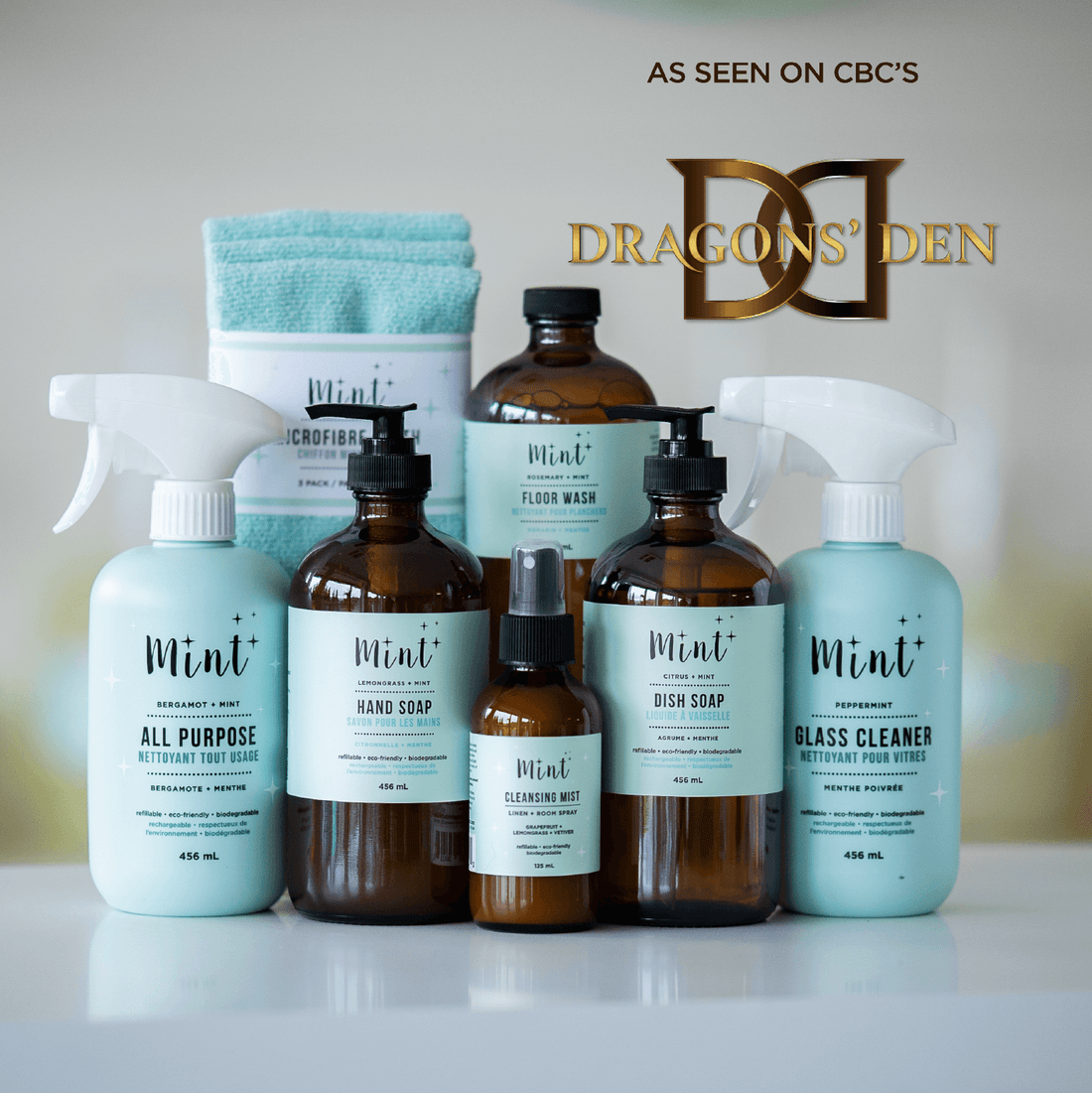A collection of Mint Cleaning Products, including hand soap, dish soap, all-purpose cleaner, glass cleaner, floor wash, cleansing mist, and microfiber cloths. The image features a "As seen on CBC&