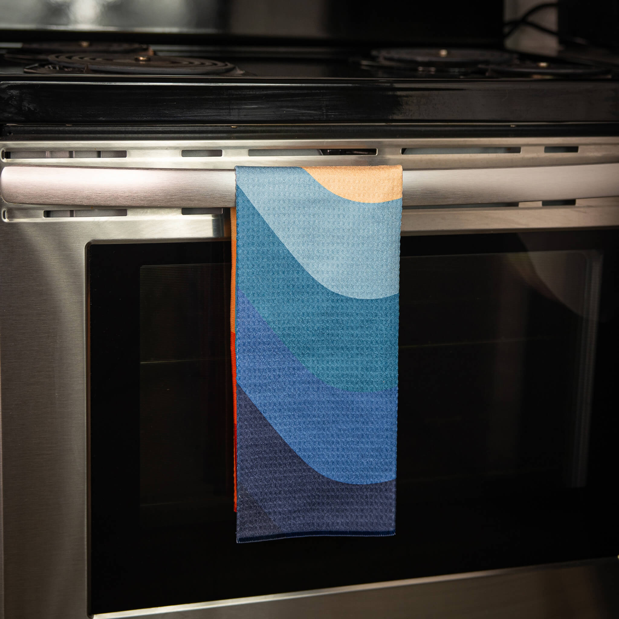Multicolored towel hanging on a stove handle