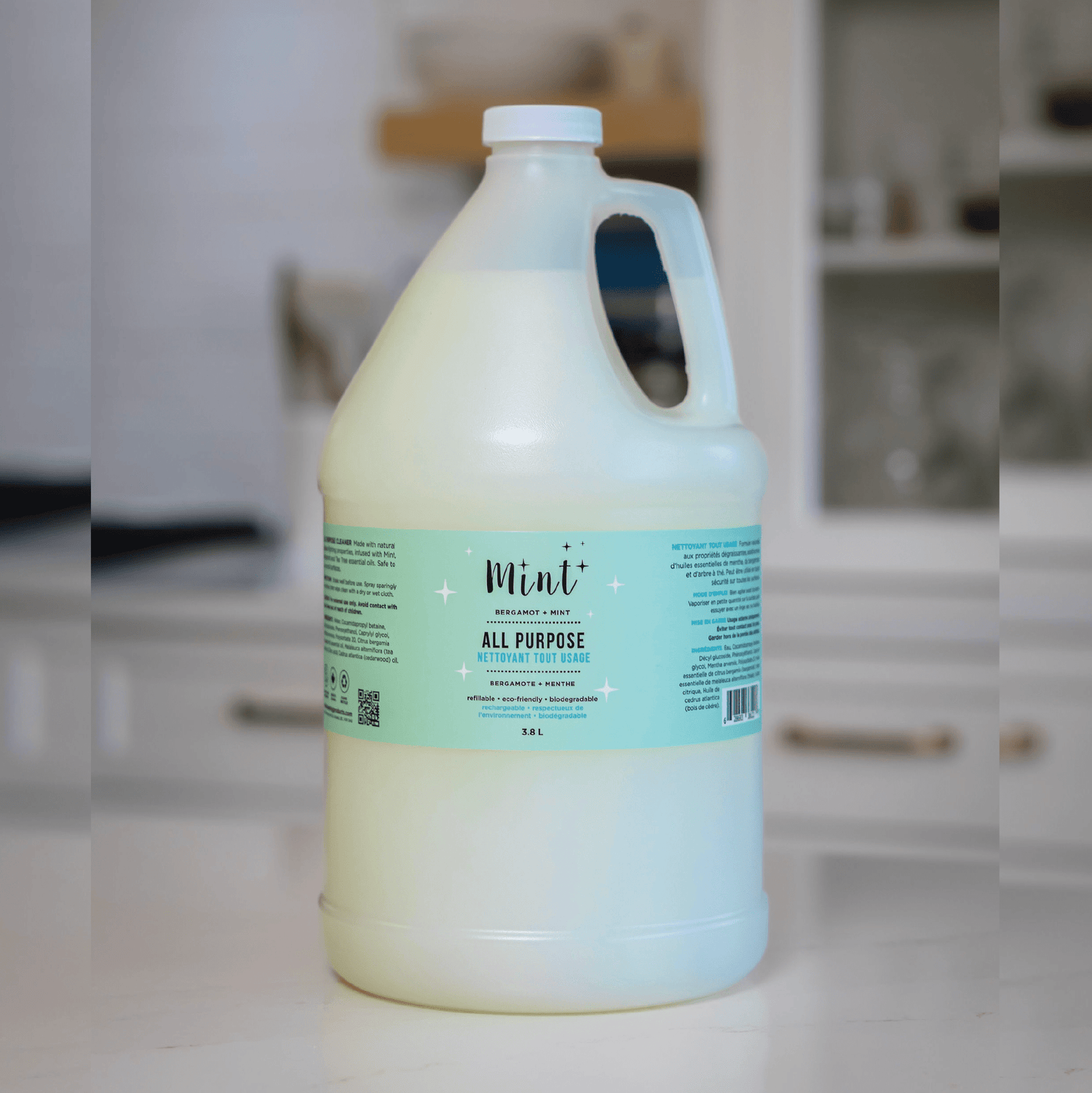 Mint All-Purpose Cleaner in a 3.8L refill jug, placed on a kitchen counter. The jug features an easy-pour handle and a label highlighting its natural ingredients and eco-friendly properties.