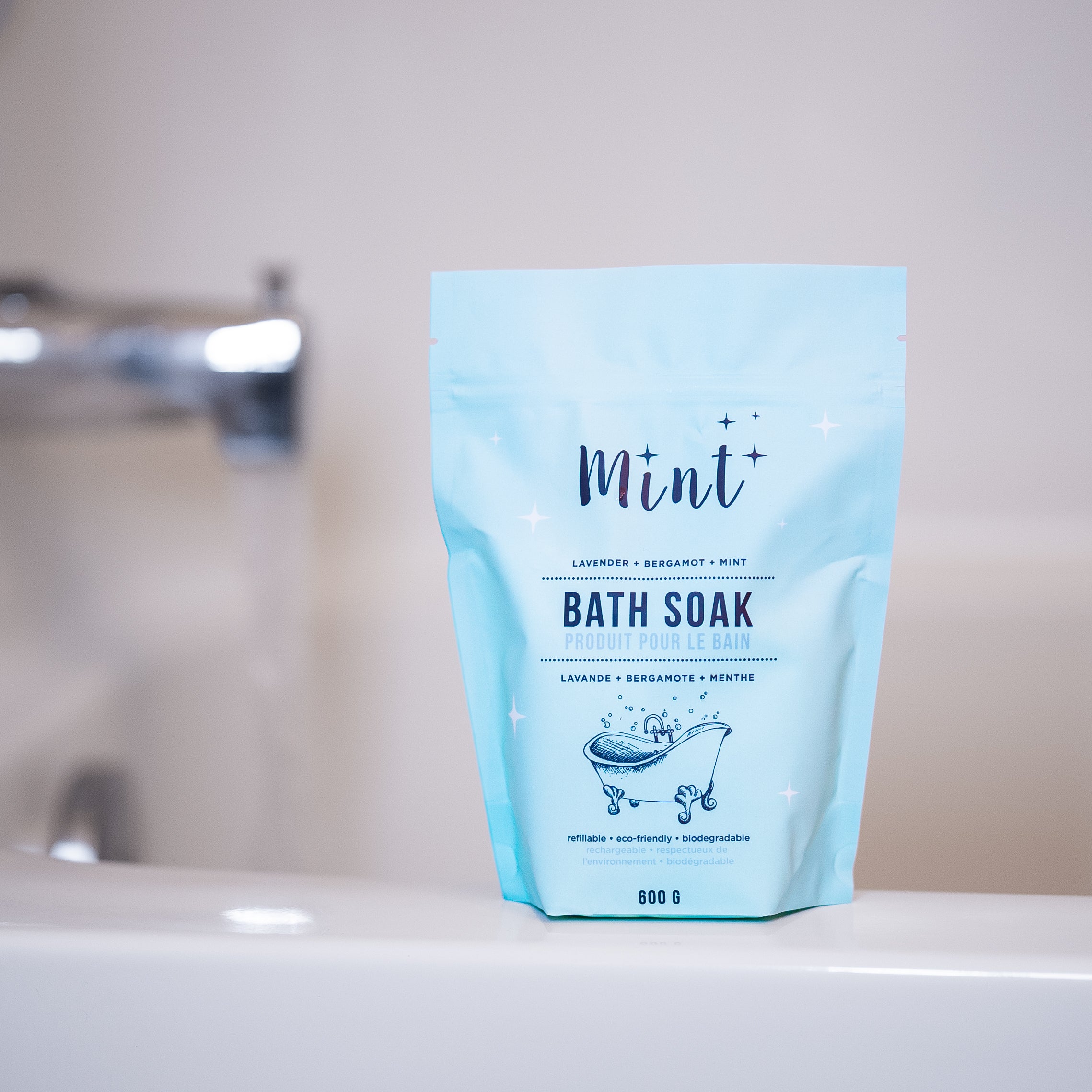 Mint Bath Soak pouch with lavender, bergamot, and mint essential oils displayed on a bathtub ledge, perfect for a relaxing bath experience.