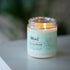 Mint Clean Home soy coconut candle with grapefruit, lime, and mint scent, lit and placed on a table, creating a warm and inviting ambiance.