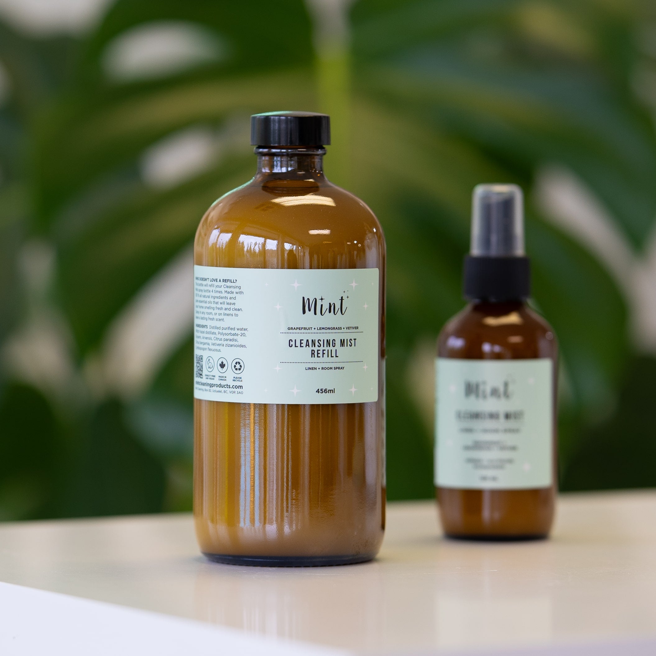 Mint Cleansing Mist Refill in a 456ml amber glass bottle, shown alongside the smaller spray bottle, ideal for refilling and refreshing your linen and room spray.