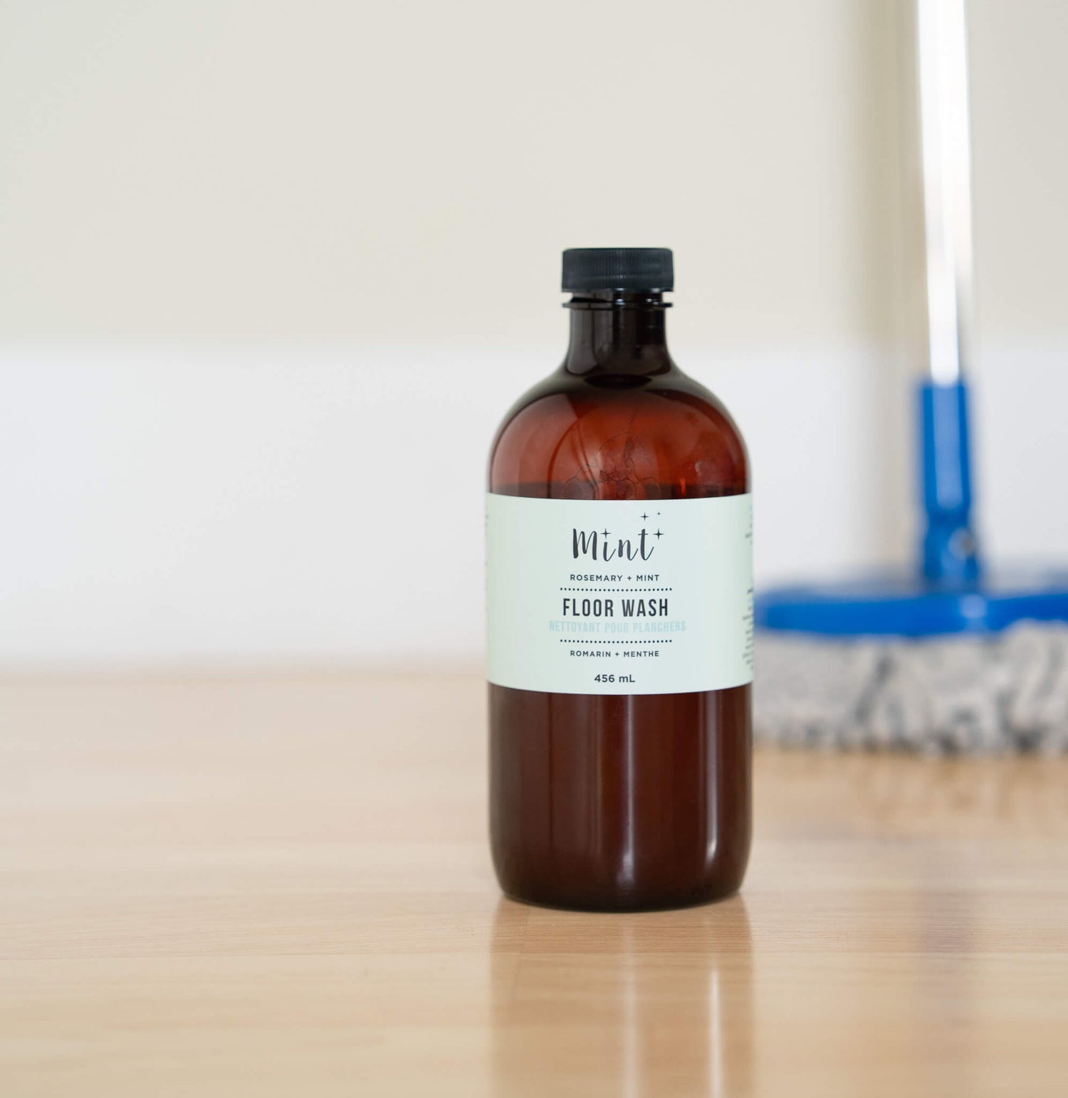 Bottle of floor wash on a wooden surface with a blurred background