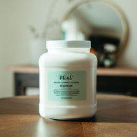 Mint brand eco-friendly deodorizer refill container on a wooden surface, with a soft, natural interior background.