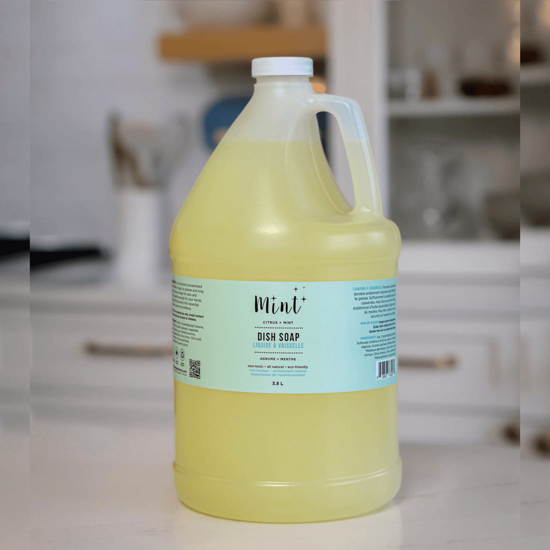 Mint Dish Soap in a 3.8L recyclable jug placed on a kitchen counter. The label highlights its natural, eco-friendly ingredients and citrus mint scent.