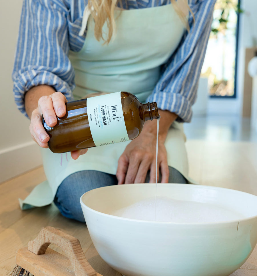 Person pouring Mint Floor Wash into a bowl with water, showcasing its natural cleaning power for floors.