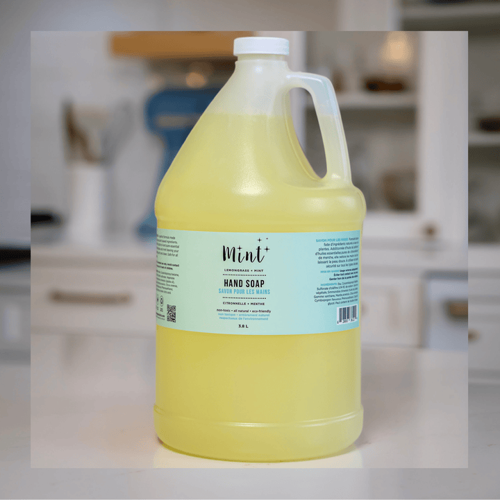 Mint Lemongrass & Mint Hand Soap in a 3.8L refill jug with an easy-pour handle, displayed on a kitchen counter. The label highlights its natural and eco-friendly ingredients.