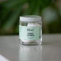 Refillable jar of Mint Shower Steamers with visible white shower tablets inside, set against a soft natural backdrop, highlighting the product’s eco-friendly and biodegradable features.