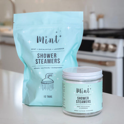 Mint Shower Steamers refill bag and glass jar displayed on a kitchen counter, showcasing eco-friendly and biodegradable packaging.