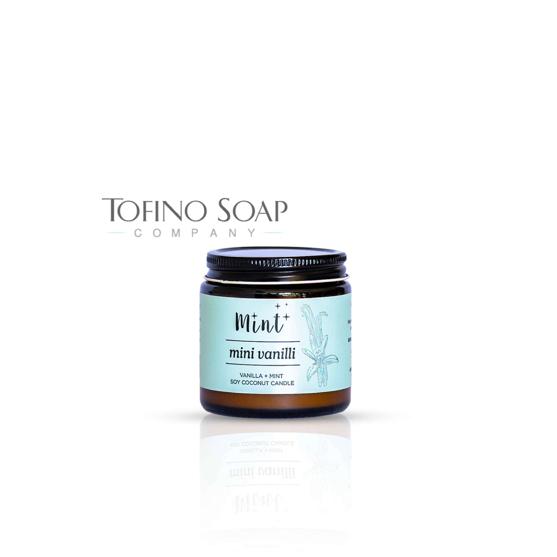 Mint Cleaning Products soy coconut candle in an amber glass jar with a black lid. The mint green label features the scent &