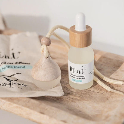 Bottle of diffuser oil with wooden dropper on a wooden surface