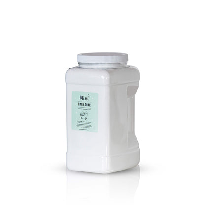 A large white plastic container with a handle, labeled &quot;Mint+ Bath Soak.&quot; The label features a white background with minimalist design elements. The container is placed against a light mint background, reflecting a clean and calming aesthetic.