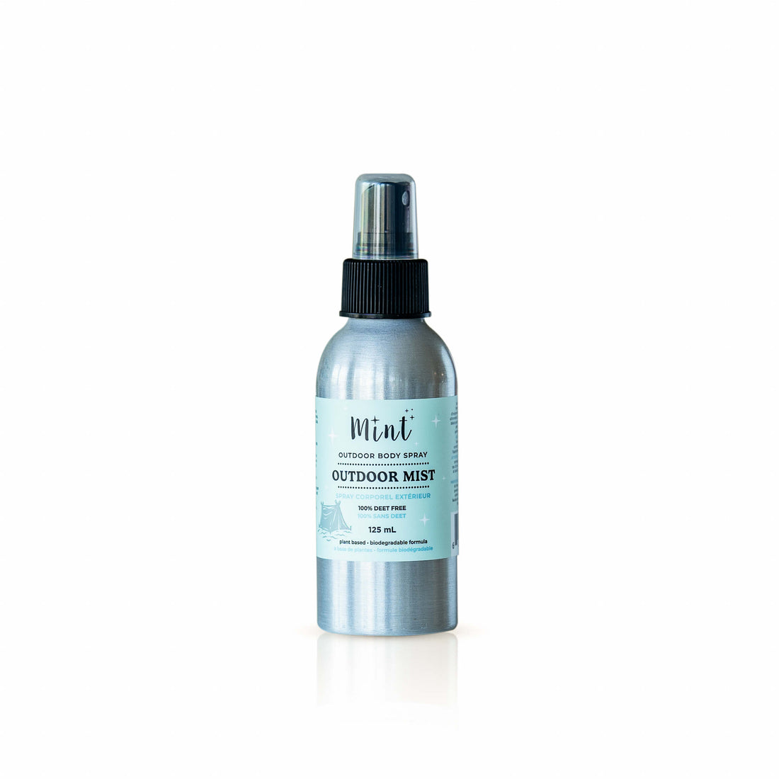 A silver aluminum spray bottle of Mint Outdoor Mist sitting on a wooden railing with a blurred green forest background. The label indicates it’s a 125 mL outdoor body spray that is DEET-free and plant-based.