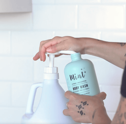 A person refills a Mint body wash bottle using a Mint body wash refill, showcasing a simple and eco-friendly refill process.